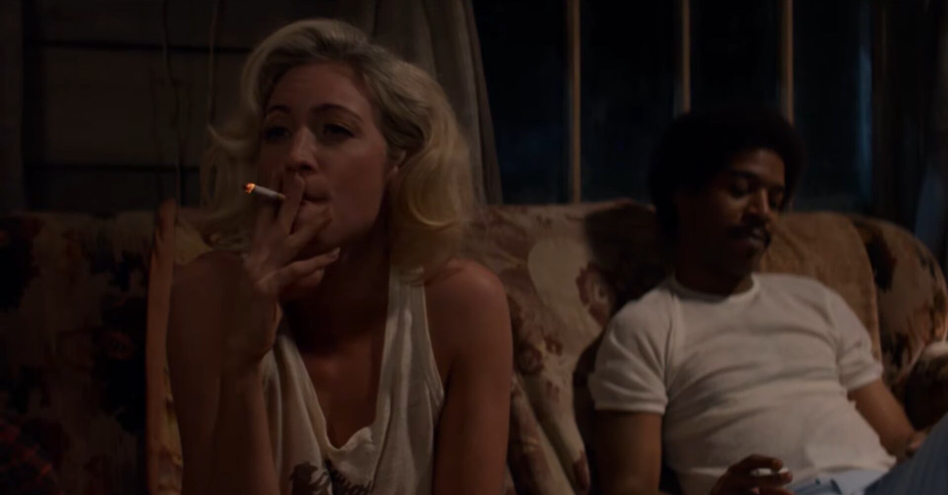 Brittany Snow fuma un cigarrillo mientras Kid Cudi se sienta a su lado en una escena de la película X de 2022.