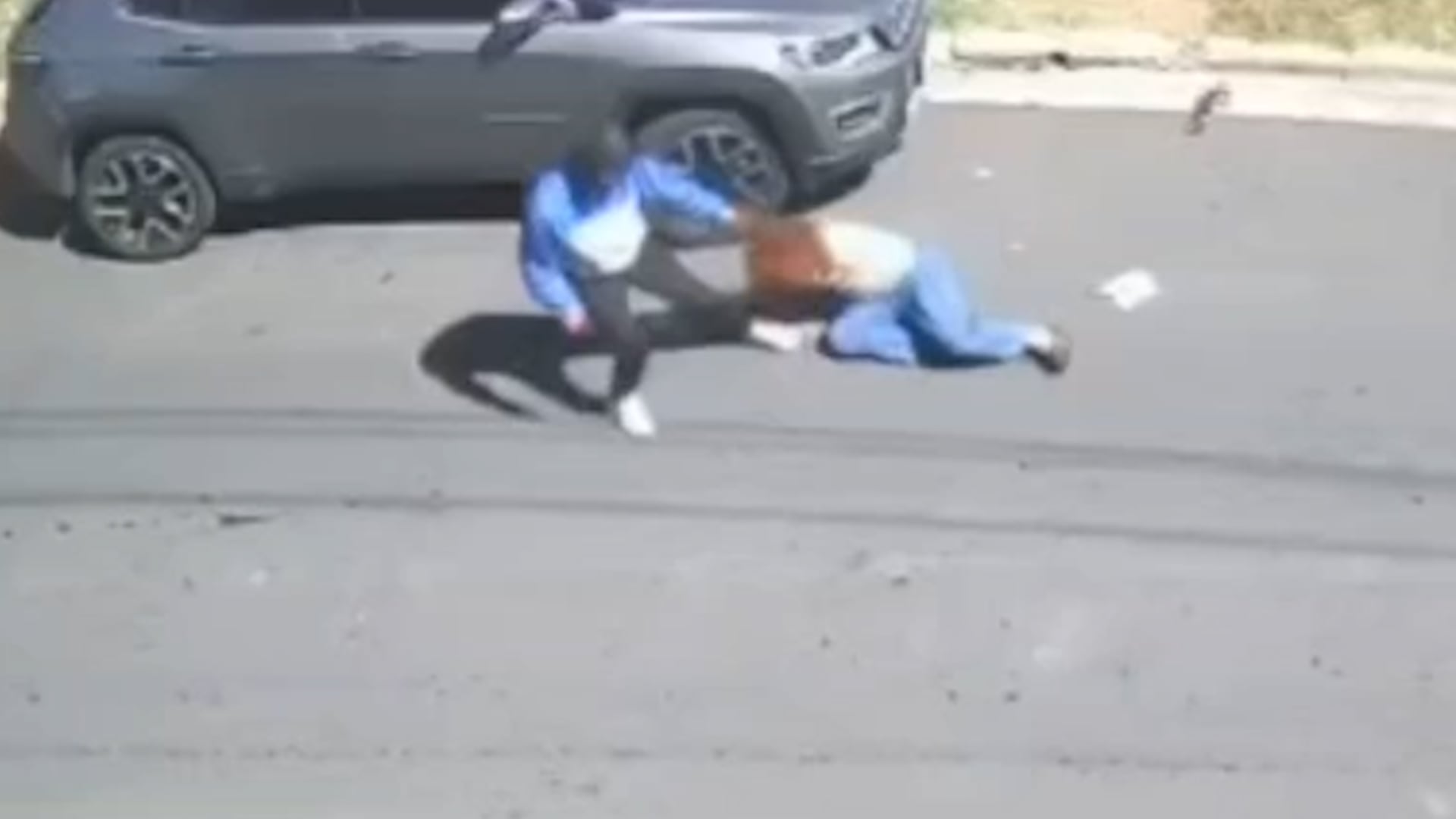 Los delincuentes sujetaron a la mujer del cabello, arrastrándola sobre el asfalto