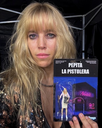 Luisana Lopilato, con cabello rubio y saco brillante, sostiene el empaque de un juguete con la inscripción Pepita la pistolera