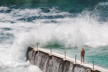 Una mujer frente a la playa Bondi en Sydney, Australia (Magnific)