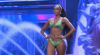 Zuliet Seminario posa con un traje de baño verde de dos piezas en un escenario con pantallas de fondo azul
