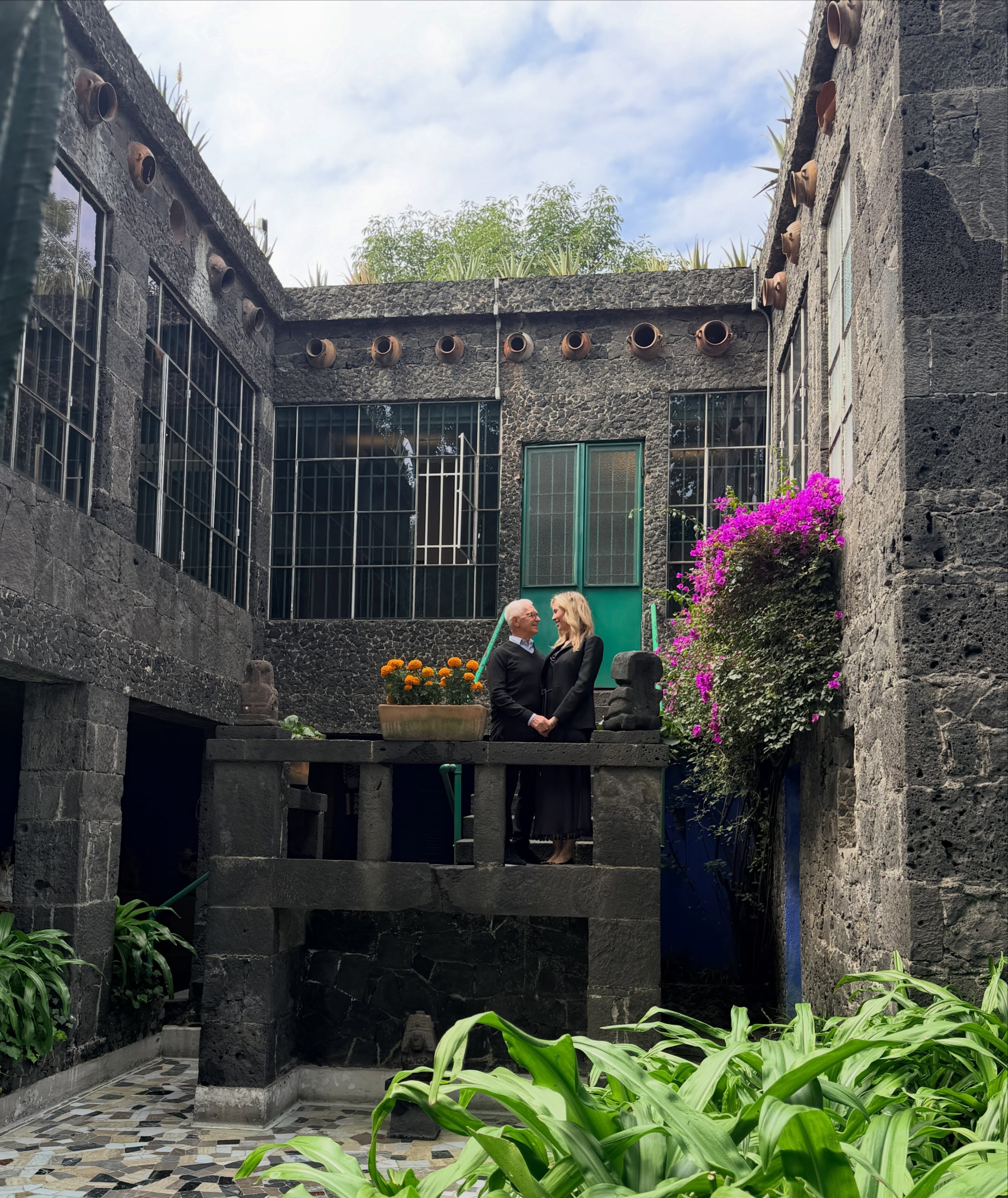 Eduardo y Elina Costantini posan en una estructura de piedra dentro del patio del Museo Frida Kahlo durante su viaje familiar a Ciudad de México.