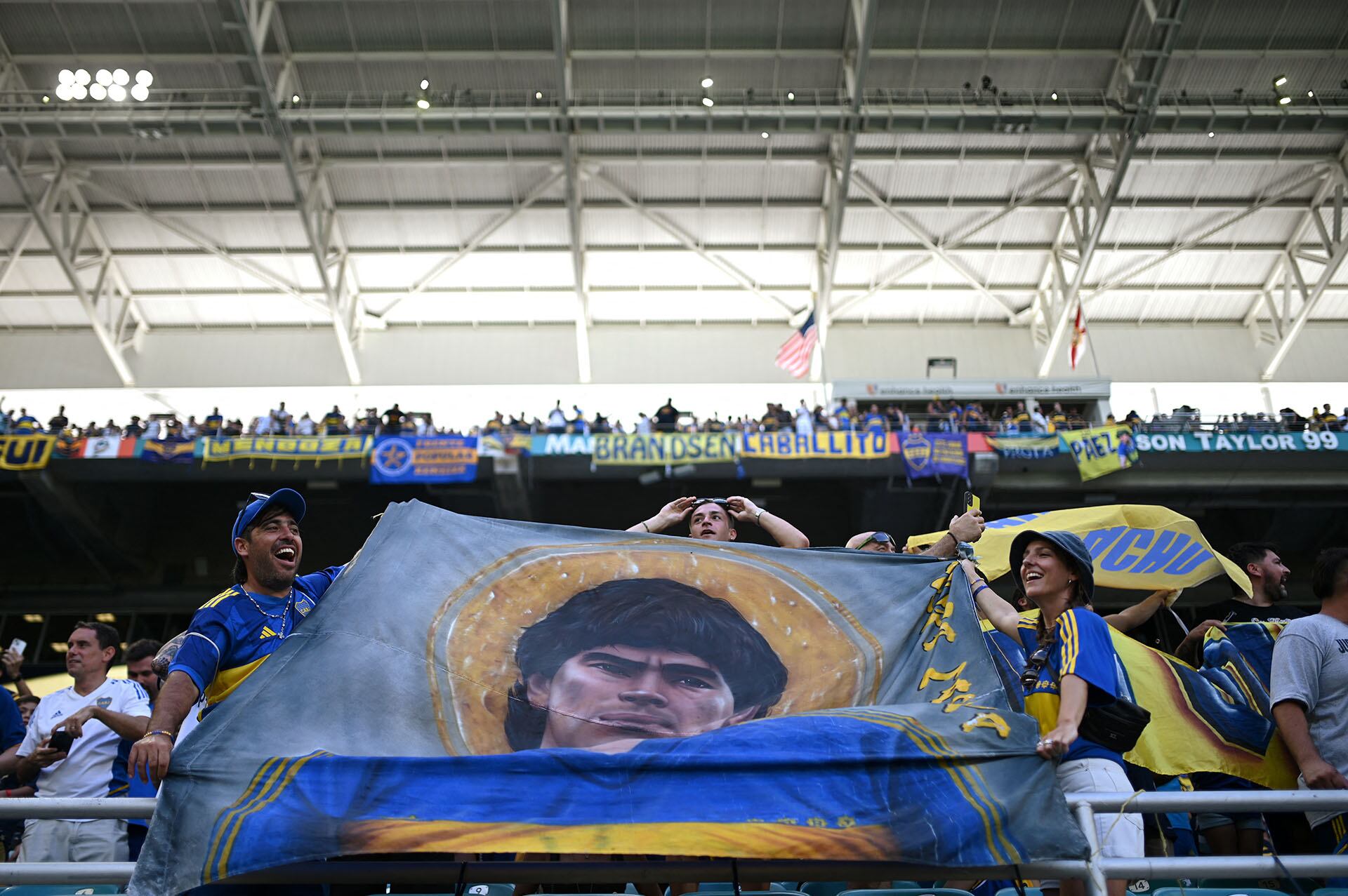 Fans of Boca Juniors hold a flag with the image of late Argentine football legend Diego Maradona before the FIFA Club World Cup 2025 Group C football match between Argentina