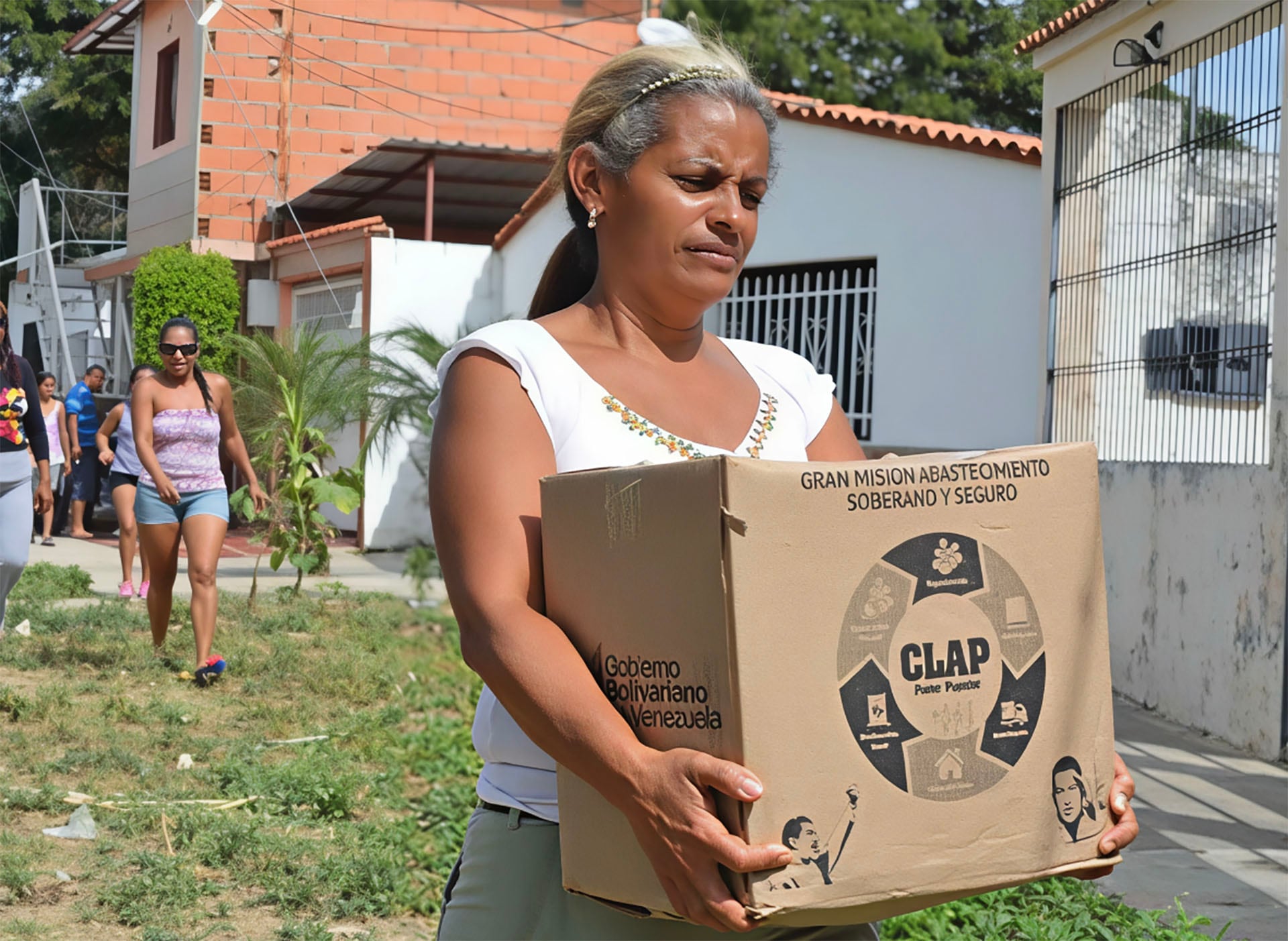 Una mujer traslada una caja de alimentos en su comunidad