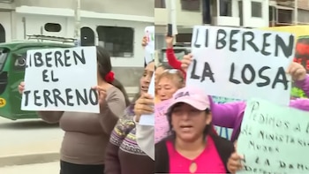 Varias mujeres, algunas con carteles con texto 'LIBEREN EL TERRENO' y 'LIBEREN LA LOSA', protestan en la calle junto a un mototaxi verde