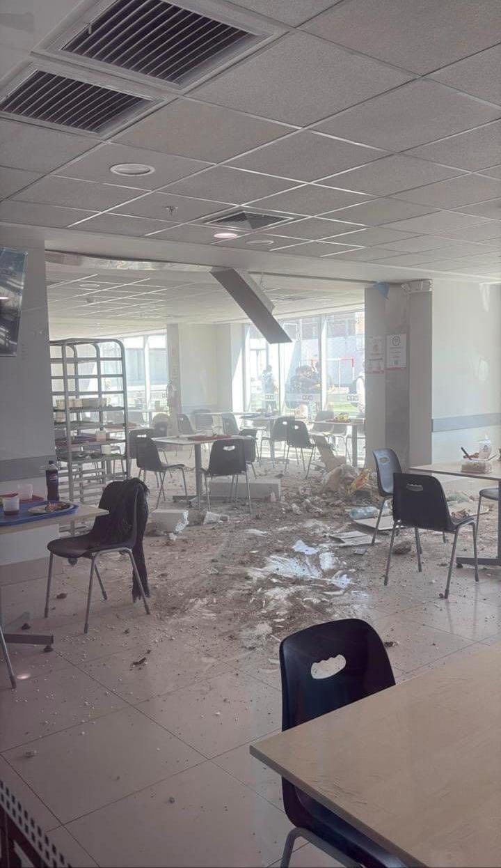 Materiales del techo y escombros cubren el suelo de una cafetería o área común, evidenciando los graves daños materiales causados por el reciente sismo en Ica. (Facebook)