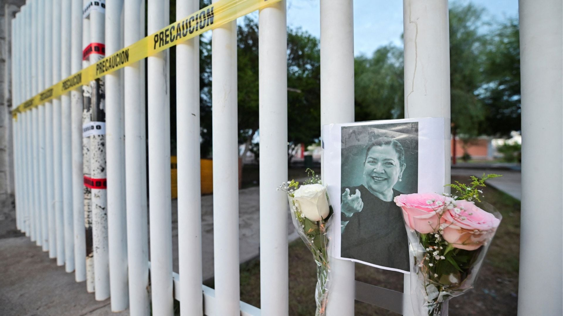 Flores y una fotografía de la subdirectora cuelgan de la cerca exterior de la Escuela Secundaria No. 13 luego de un ataque que la mató e hirió a otros, según las autoridades locales, en Torreón, estado de Coahuila, México, el 1 de octubre de 2026. REUTERS/Enrique Terrazas