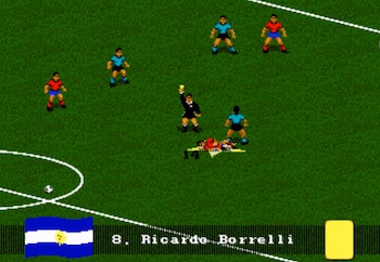 Captura de pantalla de un videojuego de fútbol retro. Árbitro levanta tarjeta amarilla cerca de jugador caído. Otros jugadores, bandera argentina y '8. Ricardo Borrelli' visibles
