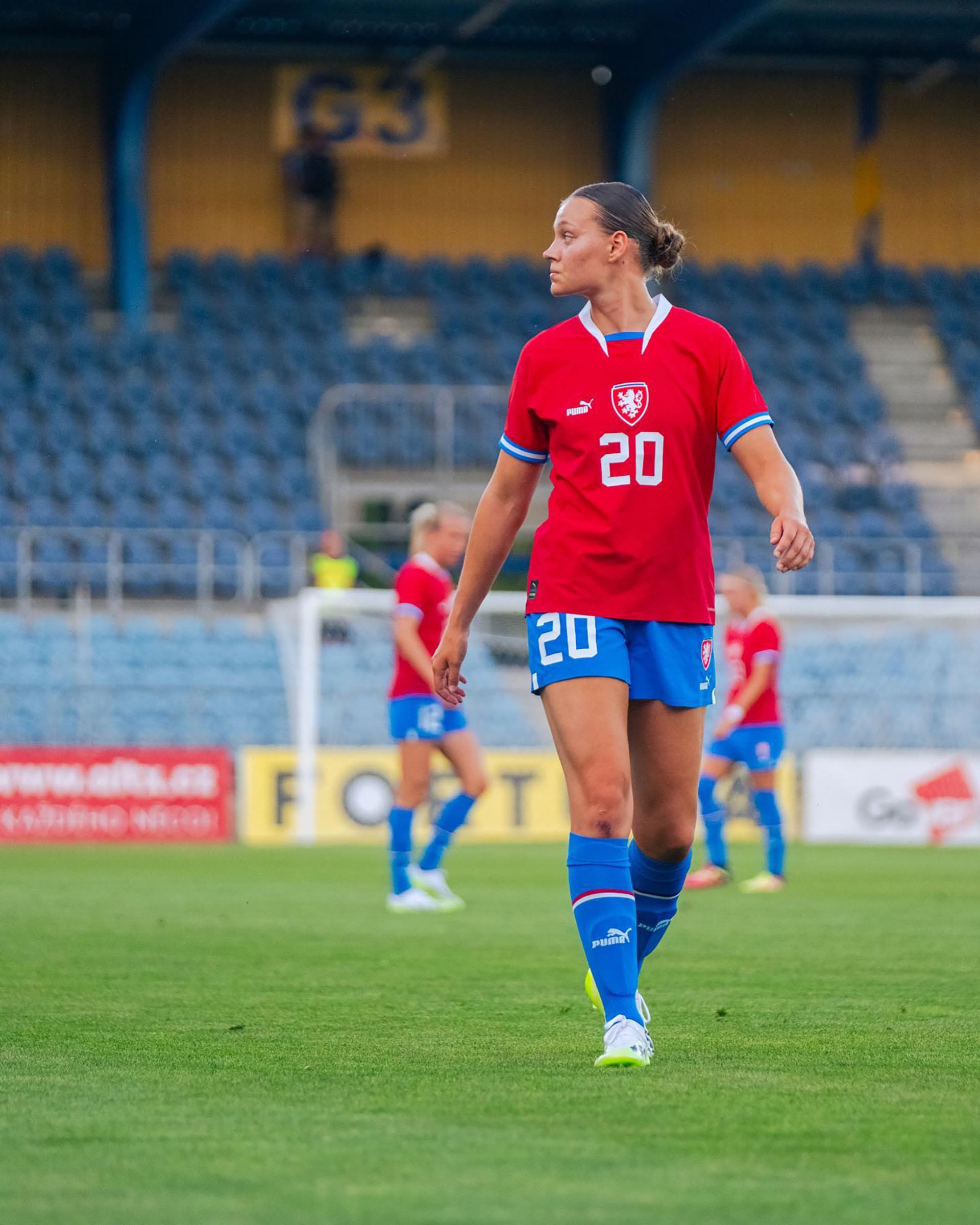 La futbolista Jana Žufánková, con su uniforme de la selección nacional, mira atentamente el desarrollo del partido desde el césped del estadio (@jana.zufankova)