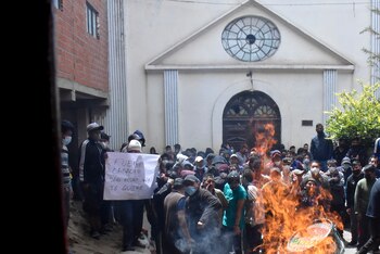 Un preso lleva un cartel que dice "Fuera Camacho, San Pedro no te quiere", durante una protesta contra el posible traslado del gobernador de Santa Cruz, Luis Fernando Camacho, a ese centro de detención en La Paz, Bolivia, el jueves 29 de diciembre de 2022. La policía detuvo el miércoles a Camacho, principal líder de la oposición, cerca de su casa en Santa Cruz. La Fiscalía General dijo que Camacho fue detenido como parte de un caso en el que él es señalado de liderar lo que el gobierno califica de golpe de Estado en 2019. (AP Foto/José Lavayen)