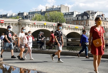 Peatones con máscaras protectoras caminan