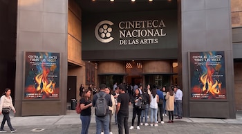Fachada de la Cineteca Nacional de las Artes con su letrero principal, carteles en los pilares y personas reunidas frente a los accesos