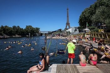 Bañistas en el Sena, ante la Torre Eiffel, para paliar el calor en Francia. (EFE/EPA/Mohammed Badra)