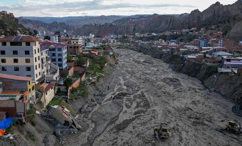 Trabajadores municipales utilizan maquinaria pesada para retirar fango del lecho del río Irpavi, donde lluvias persistentes dañaron varias viviendas en las márgenes (AP/Juan Karita)