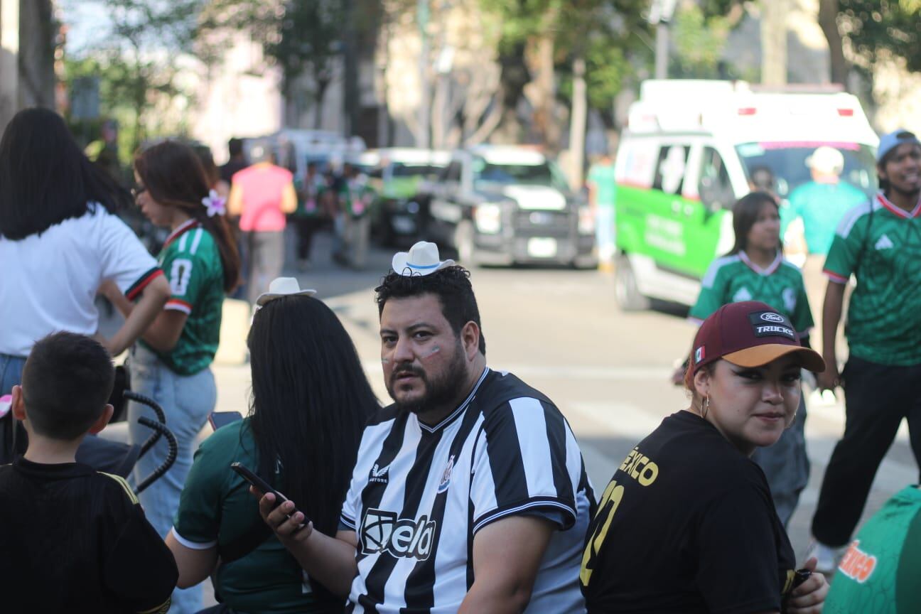 La imagen muestra a varios aficionados de la selección mexicana de fútbol reunidos en una calle de Guadalajara, vestidos con camisetas deportivas. ((Zurisaddai González/ Infobae México))
