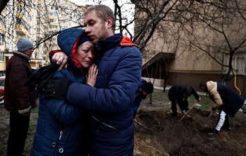 Serhii Lahovskyi, 26, hugs Ludmyla Verginska, 51, as they mourn their common friend Ihor Lytvynenko, who according to residents was killed by Russian Soldiers, after they found him beside a building's basement, following his burial at the garden of a residential building, amid Russia's invasion of Ukraine, in Bucha, Ukraine April 5, 2022. REUTERS/Zohra Bensemra REFILE - CORRECTING SPELLING OF NAMES