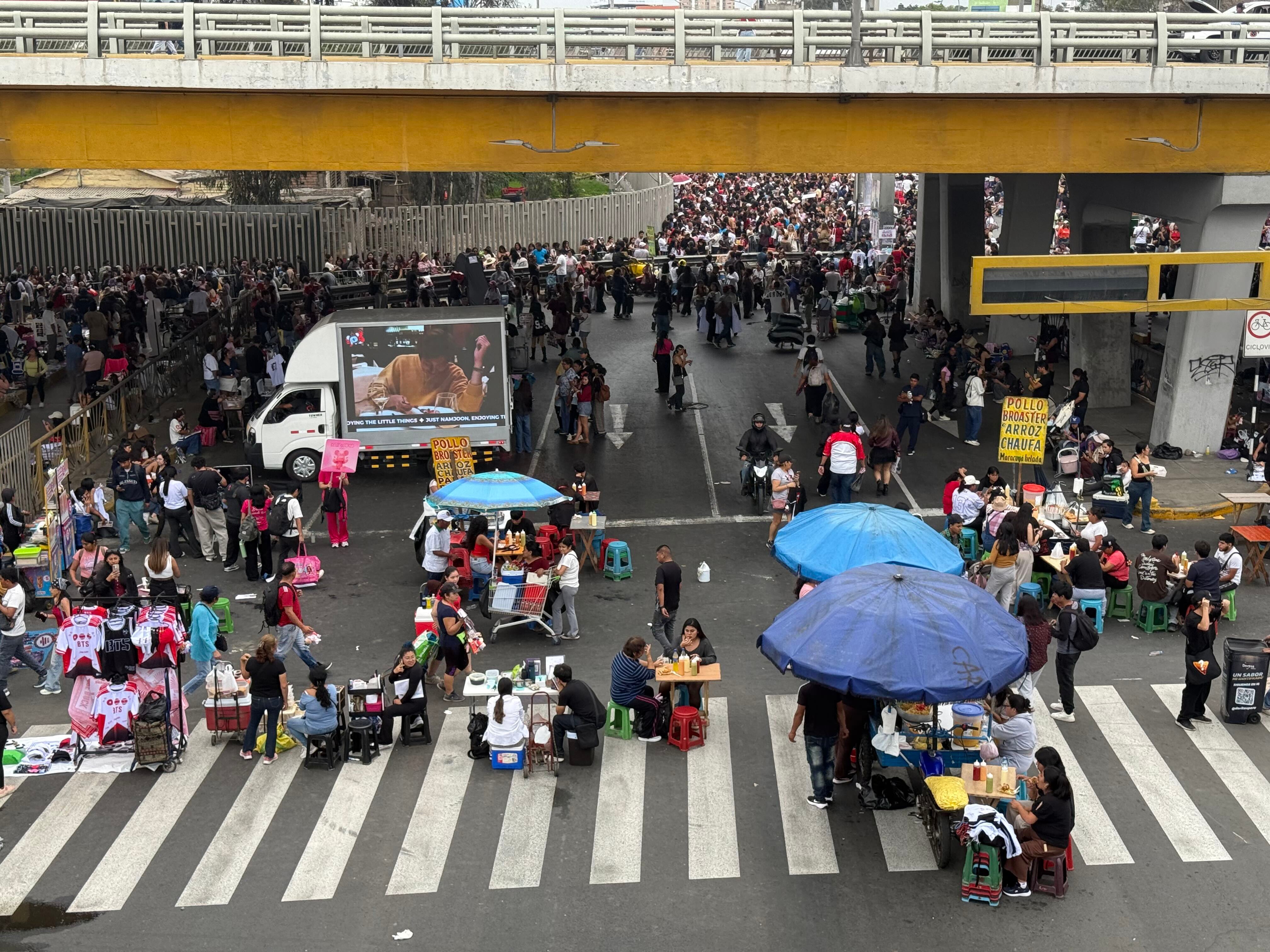 Numerosos fanáticos del grupo musical BTS y vendedores ambulantes ocupan la vía pública cerca del Estadio San Marcos en Lima. (Paula Díaz)