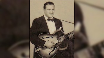 Retrato en sepia de Danny Cedrone, el guitarrista, posando con una guitarra archtop. Viste un traje oscuro, camisa blanca y pajarita