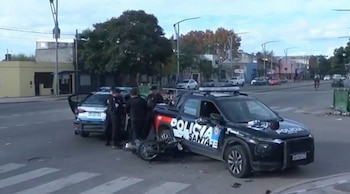 Un patrullero de la Policía de Santa Fe y una motocicleta chocada en el suelo en una intersección urbana. Varios agentes de policía rodean los vehículos