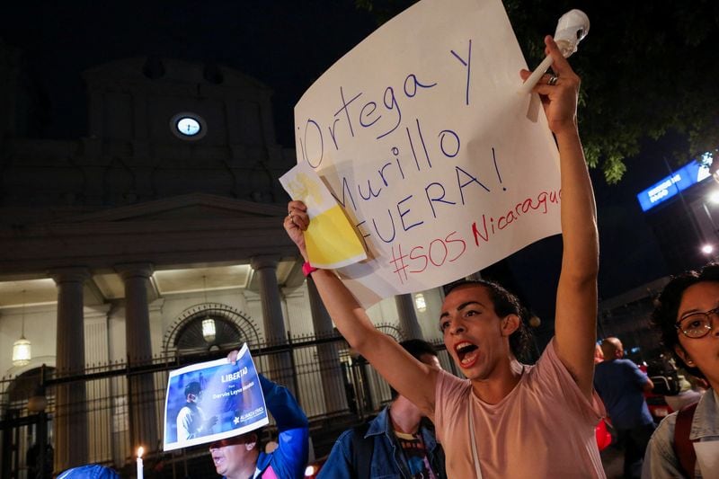 Un nicaragüense exiliado en Costa Rica sostiene un cartel en el que se lee: