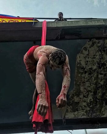 Un hombre cuelga desnudo de un puente en Medellín, como símbolo de los estragos que la violencia ha dejado en Colombia