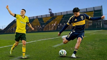Dos futbolistas en un campo de fútbol verde. Un jugador con camiseta amarilla y verde celebra, mientras otro con camiseta azul y amarilla patea un balón