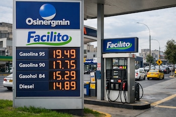 Primer plano de un cartel de precios de combustible con logos de Osinergmin y Facilito, frente a un surtidor y una avenida urbana con tránsito en Lima.
