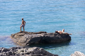 Varias personas disfrutan del último domingo de agosto en la playa de La Herradura, en la costa de Granada. (EFE/Alba Feixas)