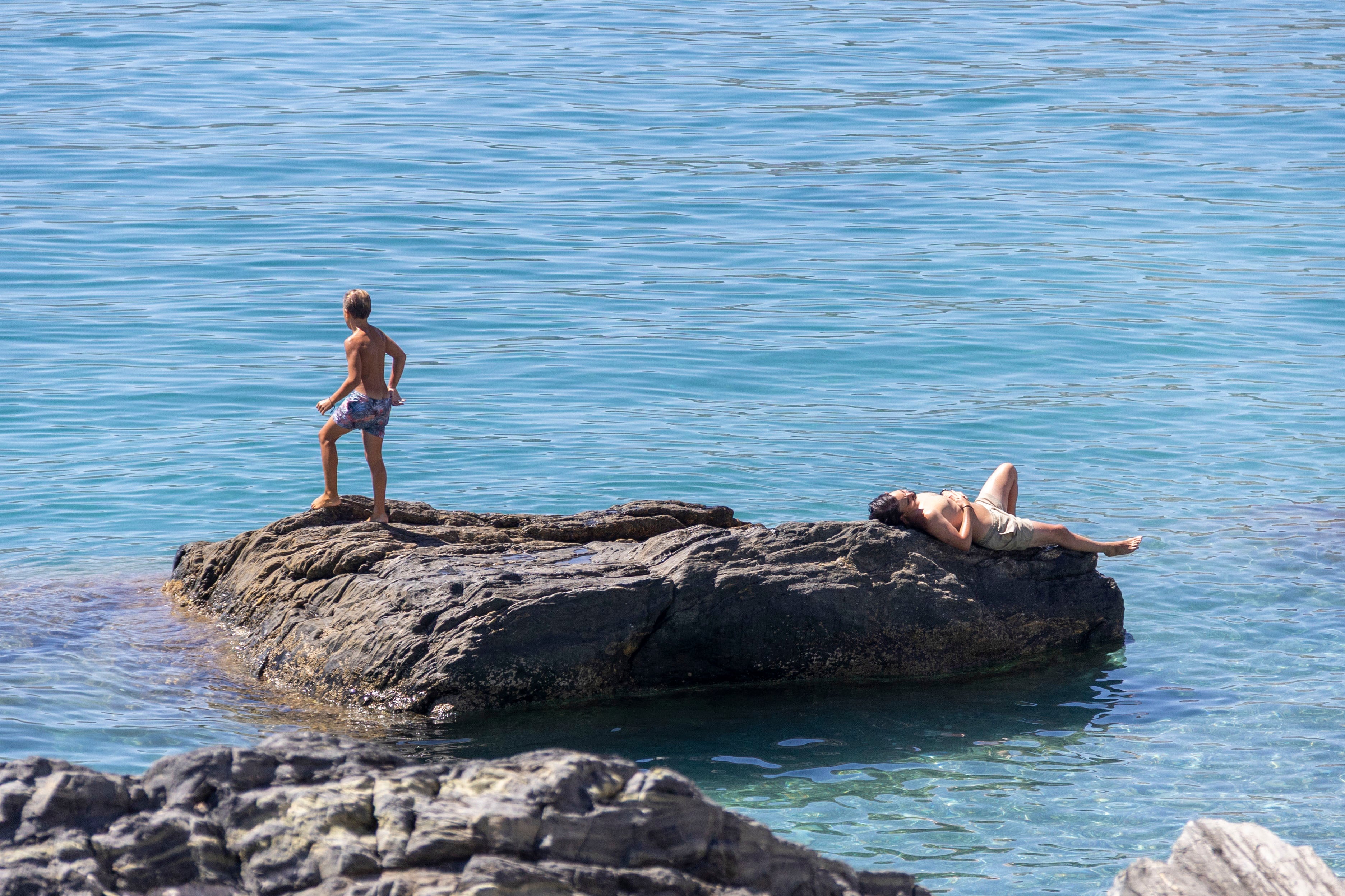 Varias personas disfrutan del último domingo de agosto en la playa de La Herradura, en la costa de Granada. (EFE/Alba Feixas)