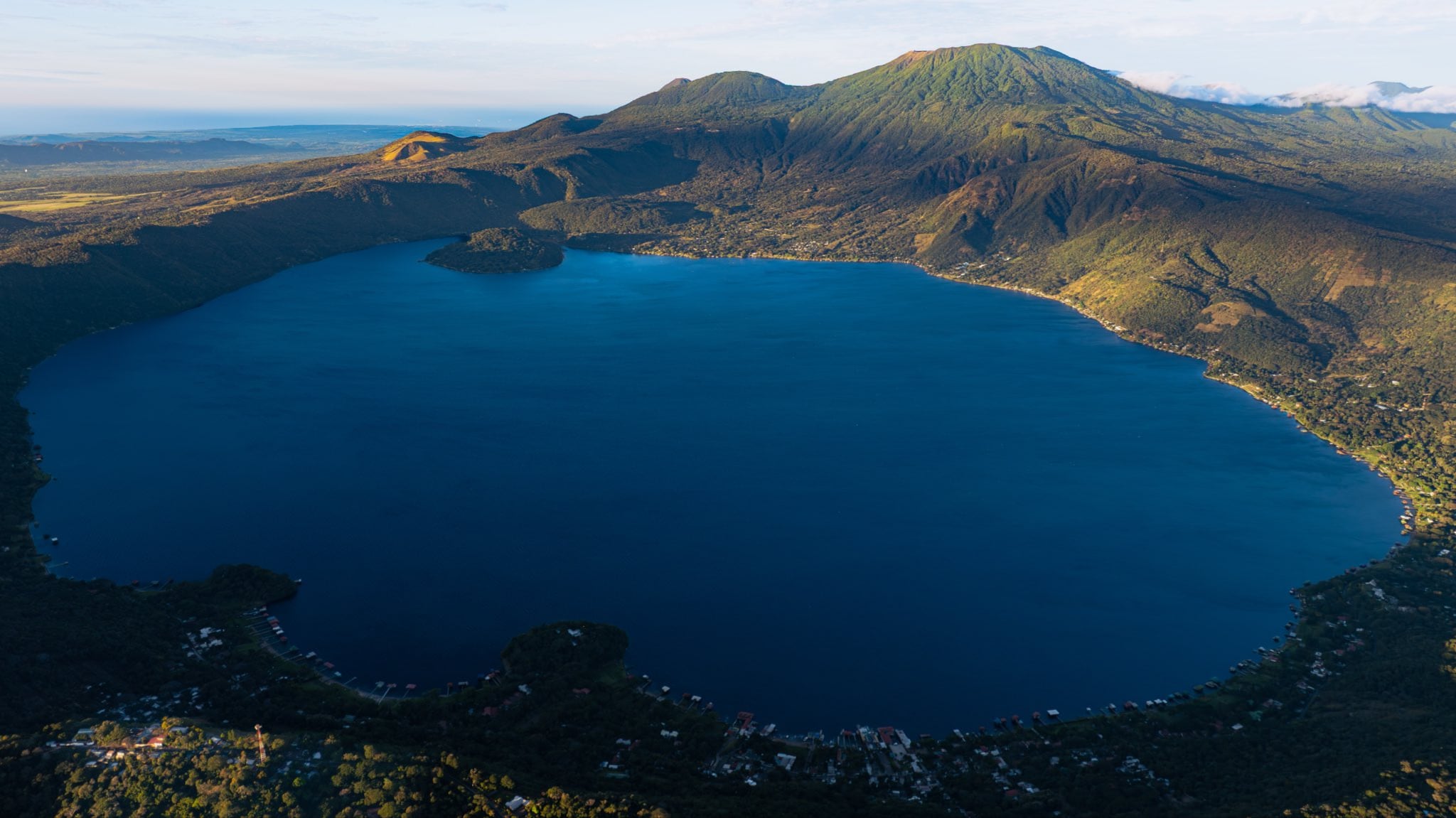 Se localiza en el departamento de Santa Ana, a unos 18 kilómetros de la ciudad de Santa Ana y aproximadamente 60 kilómetros de San Salvador. Es un destino turístico de relevancia nacional, visitado tanto por salvadoreños como por extranjeros. En sus orillas se han desarrollado instalaciones turísticas que incluyen hoteles, restaurantes, casas de veraneo, clubes náuticos y centros de recreación. Las actividades principales comprenden natación, navegación en lancha, kayak, buceo recreativo y pesca deportiva. / (El Salvador Travel)