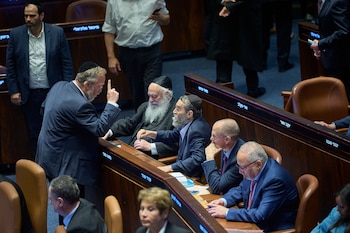 Legisladores en el Parlamento israelí discuten tras la votación de un proyecto de ley que busca igualar el estudio de los textos judíos con el servicio militar, en Jerusalén, el lunes 13 de julio de 2026. (AP Foto/Ohad Zwigenberg)