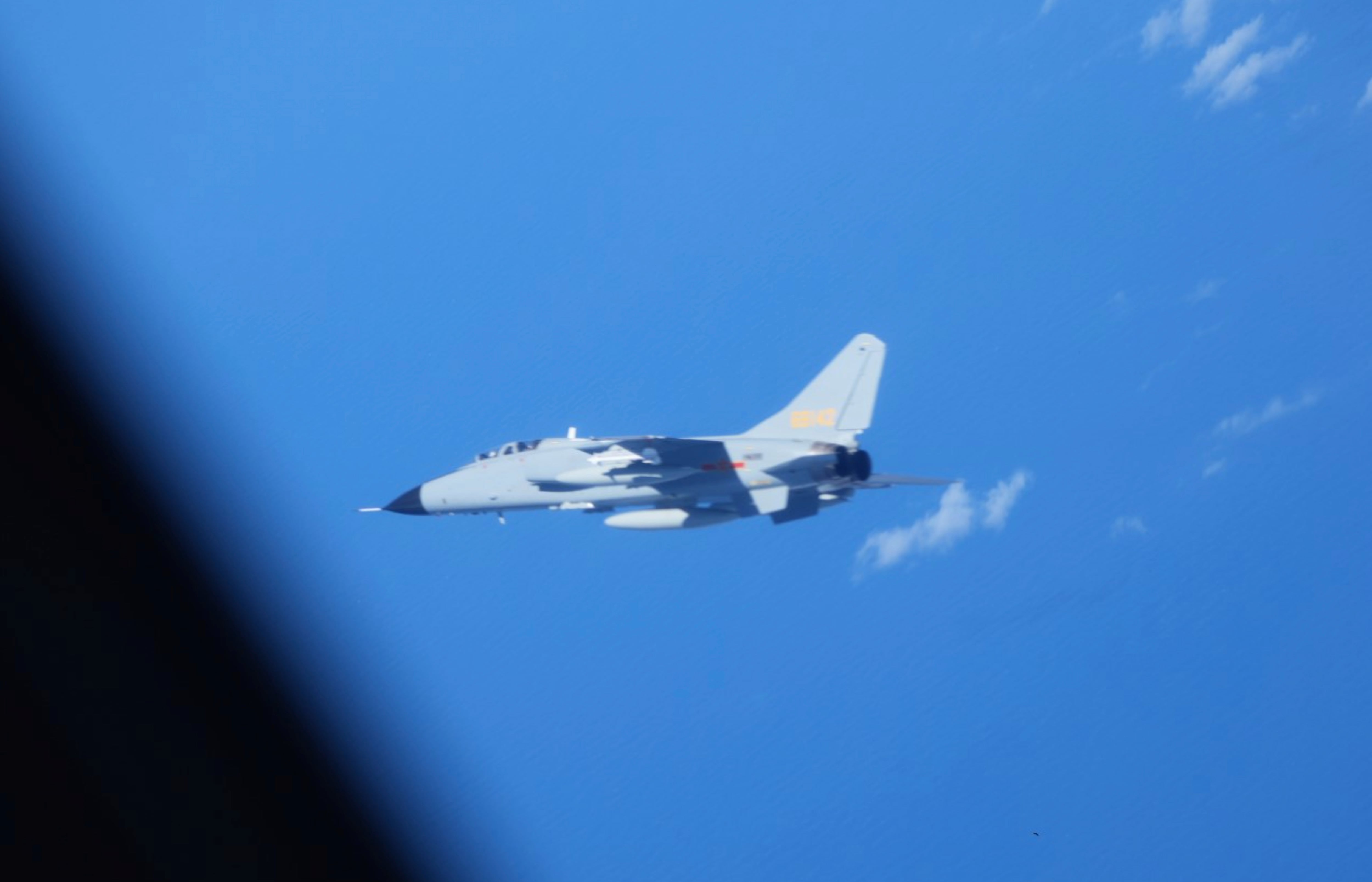 Se observa un cazabombardero chino JH-7 (en el centro) cerca de un avión de inteligencia electrónica YS-11EB (Ministerio de Defensa de Japón vía AP)