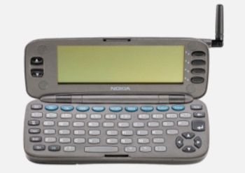 Nokia 9000 Communicator gris abierto, con pantalla rectangular, teclado QWERTY completo, botones de navegación y una antena plegada