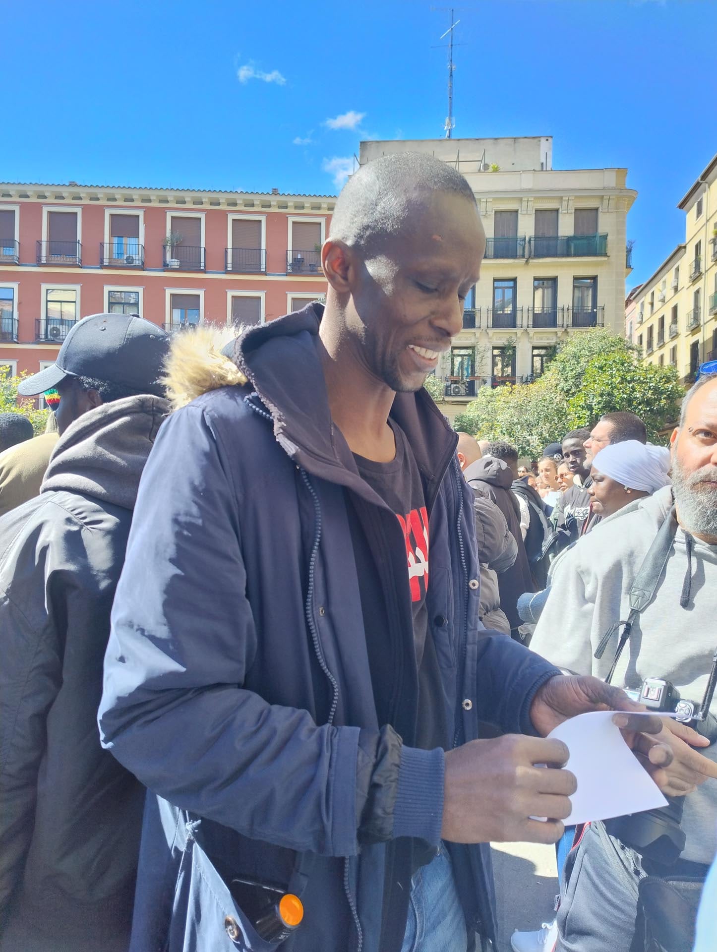 Serigne Mbaye sonríe a las personas que le acercan su apoyo, cartas y cariño después de la detención policial