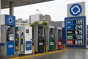 Cinco surtidores de combustible alineados frente a un panel digital de precios con un logotipo circular azul sobre fondo blanco.