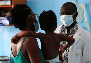 Doctor Charles Eblin prepares to take care of a girl with malaria at his clinic Centre de sante sainte Marie de Marcory in Abidjan, Ivory Coast October 7, 2021. REUTERS/Luc Gnago