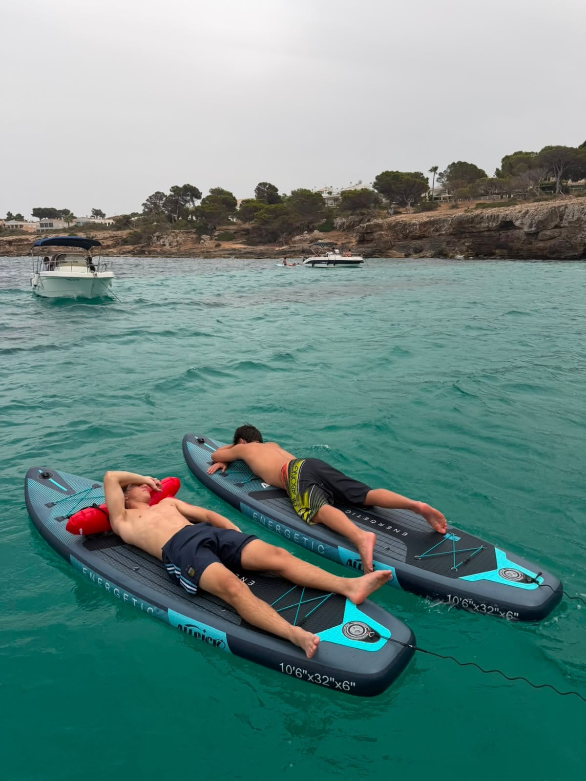 Valentino y un amigo descansaron sobre tablas de paddleboard en las aguas turquesas de la isla española