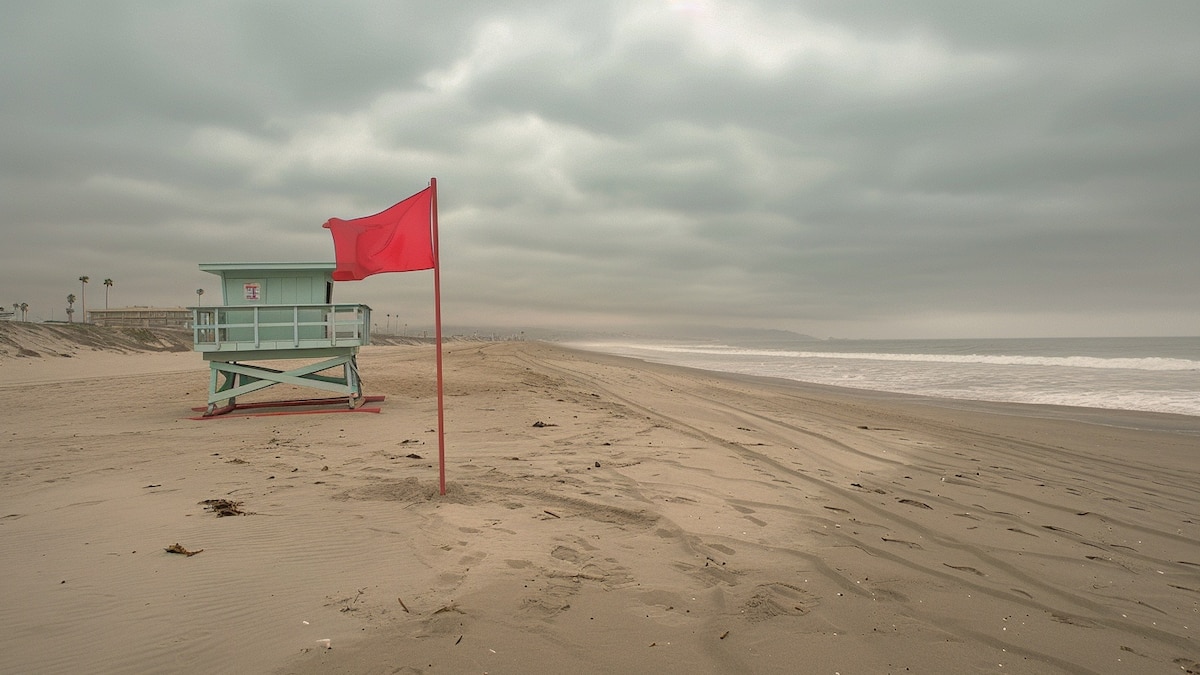 Guardavidas izando una bandera en la playa indicando el estado del mar