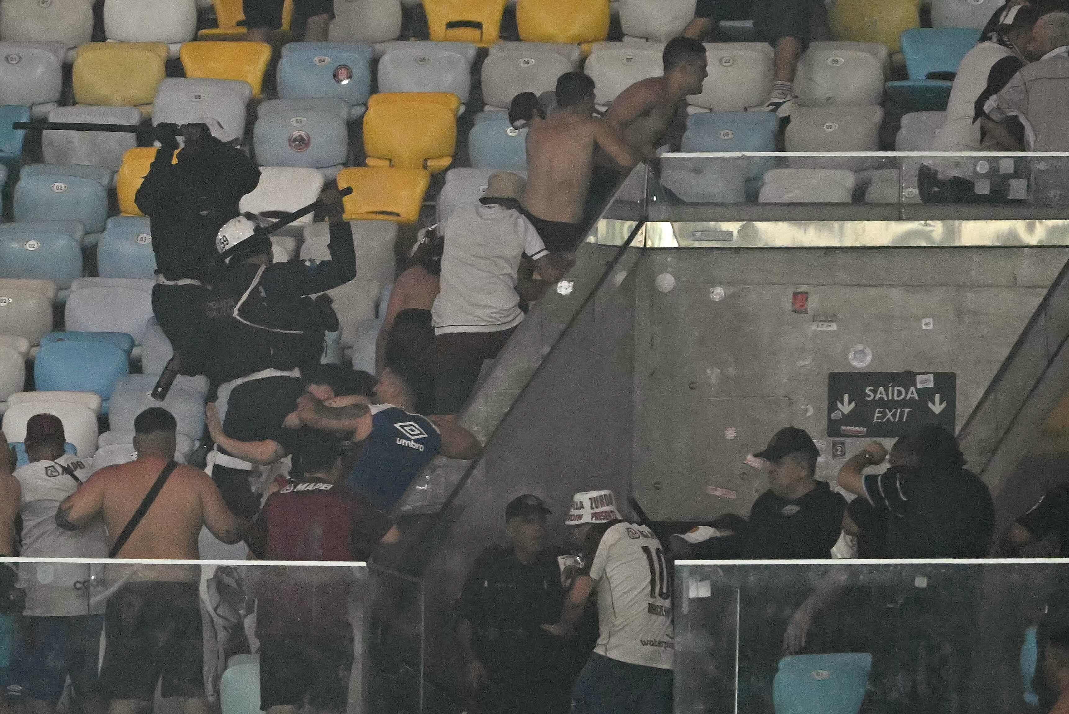Oficiales de policía brasileños chocan con los fanáticos de Lanús durante el partido de vuelta de los cuartos de final de la Copa Sudamericana entre Fluminense de Brasil y Lanús en el Estadio Maracaná de Río de Janeiro (Foto de Mauro PIMENTEL / AFP)