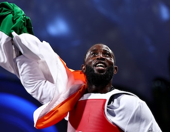 Paris 2024 Olympics - Taekwondo - Men +80kg Bronze Medal Contests - Grand Palais, Paris, France - August 10, 2024. Cheick Sallah Cisse of Ivory Coast celebrates holding up a flag after winning his bout against Carlos Sansores of Mexico. REUTERS/Tingshu Wang