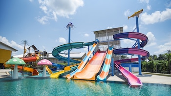 Una atracción de parque acuático con toboganes enroscados que desembocan en una piscina.