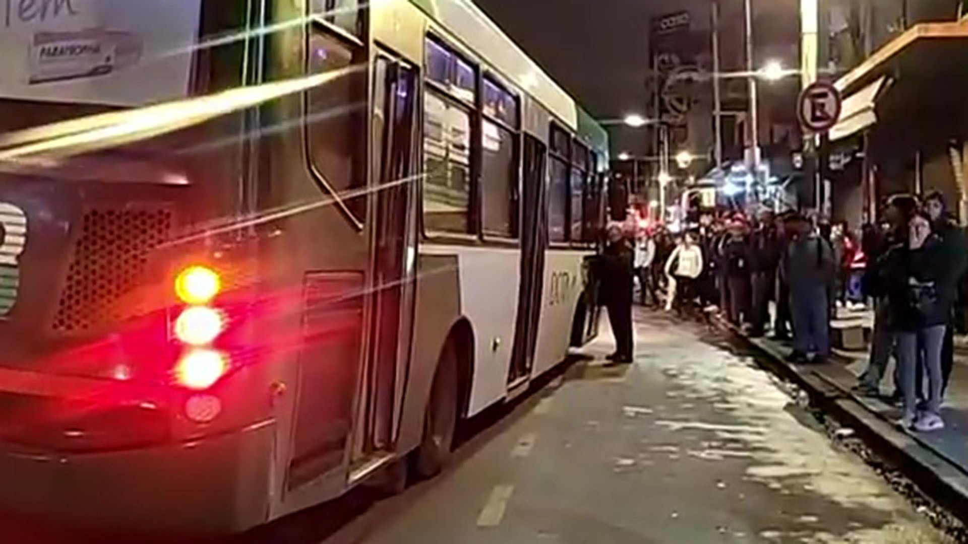 Pasajeros esperan en la calle en Constitución, enfrentando demoras significativas para abordar colectivos. (Captura de video)