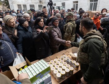 El presidente de Ucrania, Volodimir Zelensky, estrecha la mano de un residente local en un centro humanitario en la ciudad de Bucha, cerca a Kiev (Reuters)