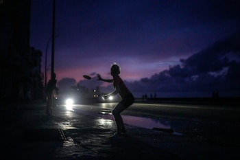 Una mujer se prepara para agarrar un frisbee durante el apagón masivo en el que derivó la caída en el funcionamiento de una de las mayores plantas termoeléctricas del país, en La Habana, Cuba, el viernes 18 de octubre de 2024 (AP Foto/Ramón Espinosa)