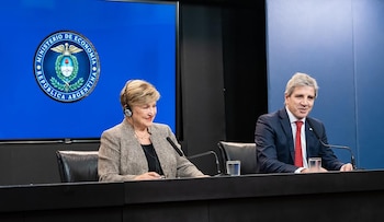 Kristalina Georgieva y un hombre sentados en una mesa con micrófonos. Detrás, una pantalla azul muestra el logo del Ministerio de Economía de Argentina