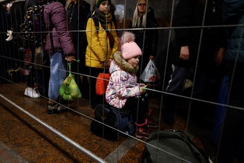 Un niño se sienta en una maleta mientras las personas que huyen de la invasión rusa de Ucrania hacen cola para tomar el tren a Polonia, en la estación de tren de Lviv, Ucrania, el 21 de marzo de 2022. REUTERS/Zohra Bensemra