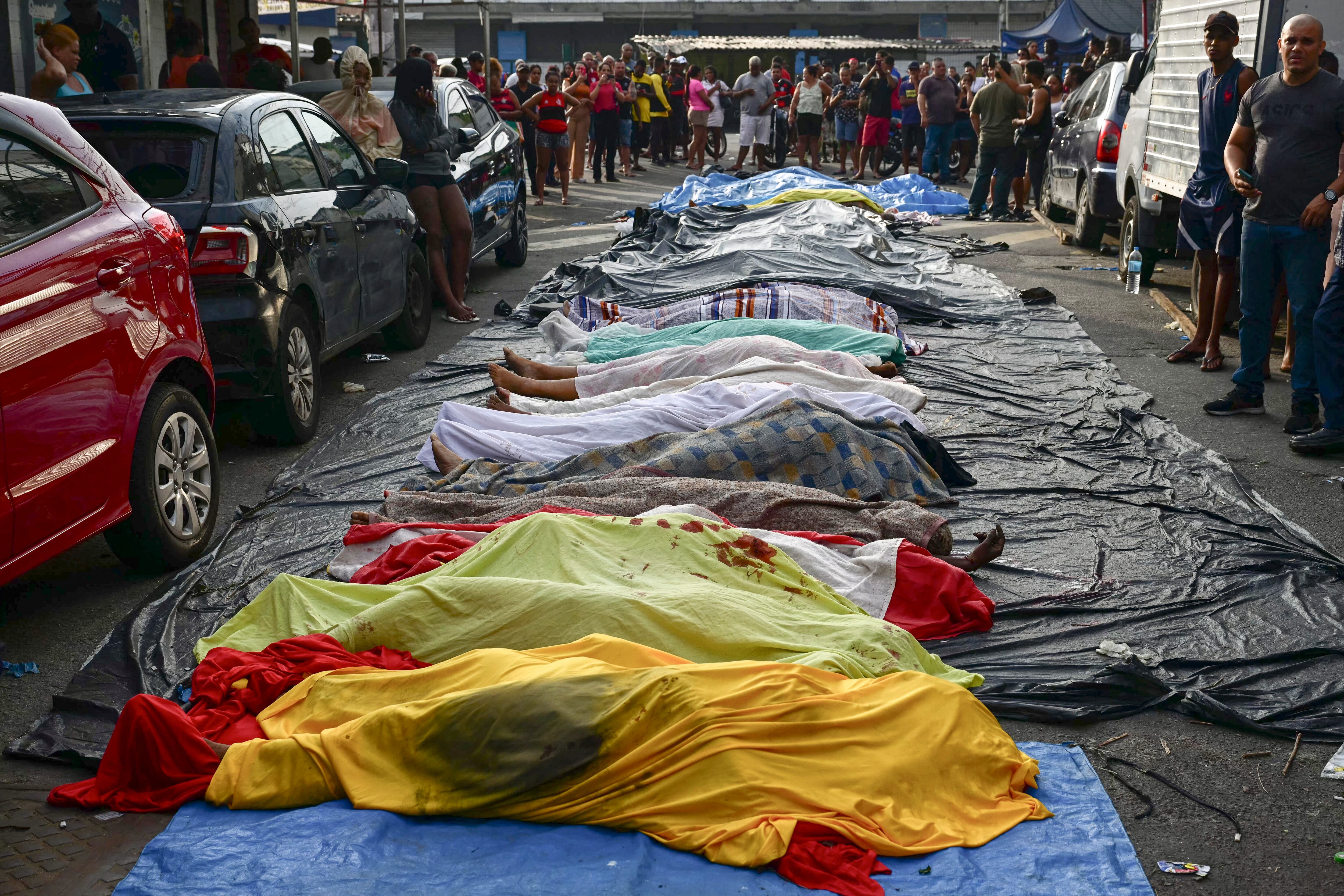 Vecinos alinearon cadáveres en la plaza Sao Lucas de la favela Vila Cruzeiro, en el complejo Penha de Río de Janeiro, Brasil, el 29 de octubre de 2025, tras la Operação Contenção (Operación Contención) (Foto de Pablo PORCIUNCULA / AFP)