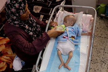 Una madre palestina alimenta a