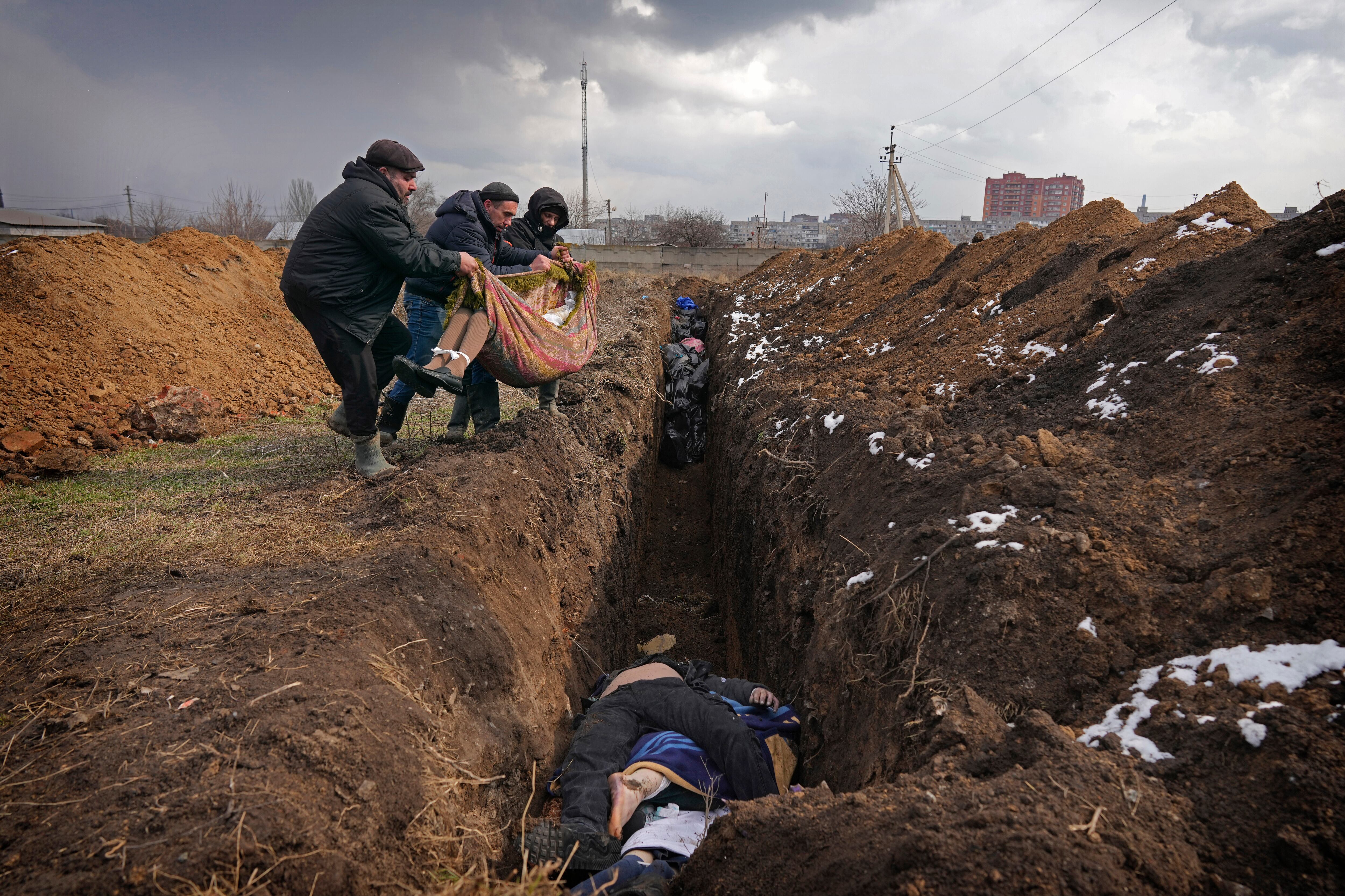 Cuerpos son depositados en una fosa común en las afueras de Mariupol, Ucrania, el miércoles 9 de marzo de 2022 (AP/Evgeniy Maloletka, Archivo)