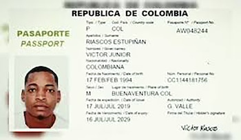 Primer plano de la página abierta de un pasaporte colombiano que muestra la foto de un hombre joven, Victor Junior Riascos Estupiñan, y sus datos personales